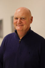 Porträt einer Person mit freundlichem Gesichtsausdruck.