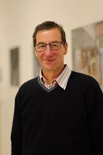 Porträt einer Person mit Brille und dunklem Pullover. Die Person blickt freundlich in die Kamera.