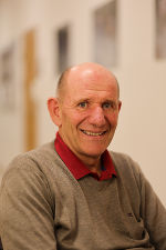 Porträt einer Person mit freundlichem Gesichtsausdruck und rotem Polohemd.