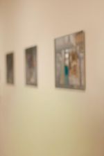 Drei gerahmte Bilder hängen an einer hellen Wand.