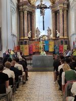 Die Schüler:innen der LBS Mitterdorf besuchen den Gottesdienst in Mariazell. Die Fahnen der unterschiedlichen Schulen sind am Altar aufgestellt